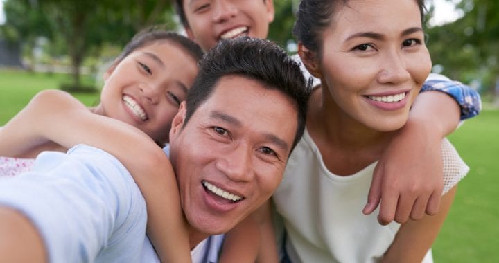 Happy Vietnamese family hugging when photographing together